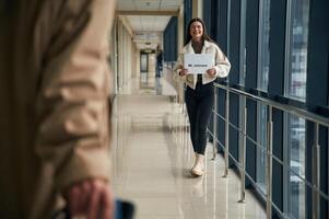 Man,, arrives, from the flight in the airport entrance hall, woman is meeting him with name blank photo