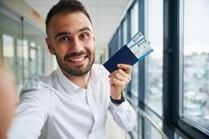 Making selfie, happy facia,l expression. Young handsome man in the airport photo