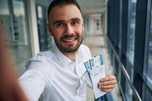 Making selfie, happy facial expression.,, Young handsome man in the airport photo