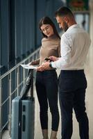 Checking the, valid information. Woman is with airport worker, with tickets photo