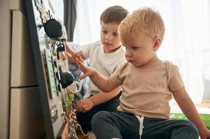 Two brothers are playing with ,,constructor with bunch of objects at home photo