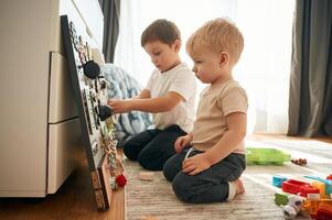Two ,brothers ,are playing with constructor with bunch of objects at home photo