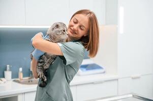After the check up, holding and smiling. Scottish fold cat in the veterinarian clinic with female doctor photo