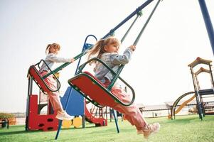 Enjoying swing ride. Kids are having fun on the playground photo