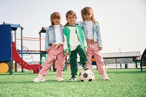 Two girl and one boy. Kids are having fun on the playground photo