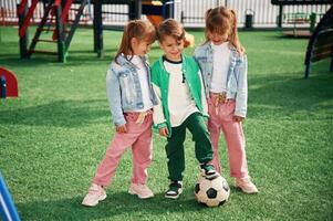 With soccer ball... Kids are having fun on the playground photo