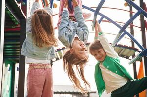 Hanging upside down... Kids are having fun on the playground photo