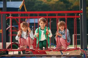 One ,boy, and two girls. Kids are having fun on the playground photo