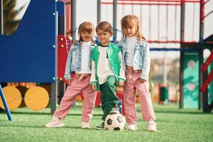 One boy, and two girls. Kids are having fun on the playground photo