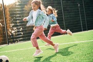 Active, weekend.. Kids are having fun on the green soccer field together photo