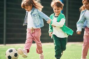 Active ,,weekend. Kids are having fun on the green soccer field together photo
