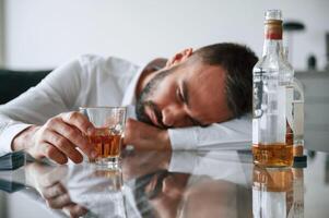 Conception of addiction. Upset young man ,drinker alcoholic is indoors photo