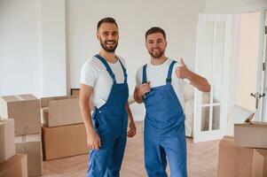 Standing and, posing. Two moving service, employees in a room photo