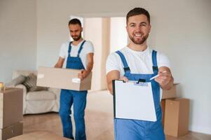 Sign in the ,documents. Two moving, service employees in a room photo