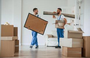 Painting and mat in hands. Two ,moving, service employees in a room photo