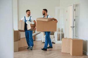 Boxes in hands. Two ,moving service employees in a room photo