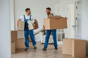 Boxes in hands. Two moving, service employees in a room photo