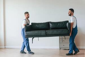 Sofa, in hands. Two moving ,service, employees in a room photo