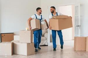 Front ,view,, holding stuff. Two moving service employees in a room photo
