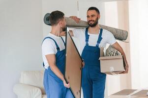 Front view,, holding stuff. Two moving service employees in a room photo
