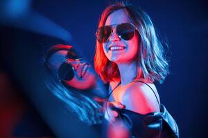 Reflection on the left side.. Cool ,young ,woman portrait in neon colors photo