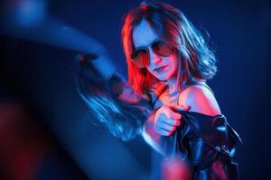 Reflection, on the left side. Cool,young woman portrait in neon colors photo