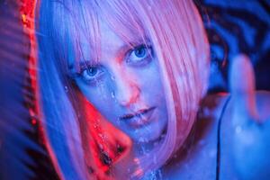 Blue color in the front and red is, behind. Stylish woman with white hair is behind wet transparent plastic sheet photo