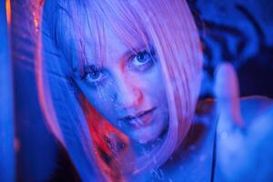 Blue color ,in the front and red is behind. Stylish woman with white hair is behind wet transparent plastic sheet photo