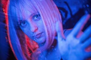 Blue color, in the front and red is behind. Stylish woman with white hair is behind wet transparent plastic sheet photo