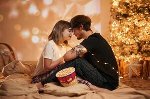 Conception of, love. Beautiful young couple indoors, celebrating new year against projector photo