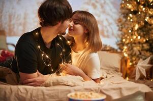 Conception, of love. Beautiful young couple indoors, celebrating new year against projector photo