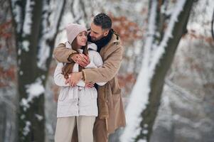 Looking, at ,each other. Lovely couple have a walk in the winter forest photo