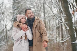 Cheerfu,l facial expression. Lovely couple have a walk in the winter forest photo