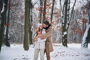 Cheerful,, facial expression. Lovely couple have a walk in the winter forest photo