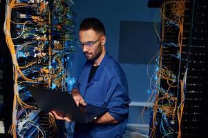 Repairman, is, busy and working with internet equipment and wires in server room photo