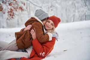 Lying down on the snow,. Mother, and her daughter is on the winter meadow and forest photo