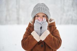 Shocked,,, covering ,face with hands. Portrait of cute little girl on the winter field photo