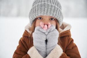 Shocked,, covering face with hands. Portrait of cute little girl on the winter field photo