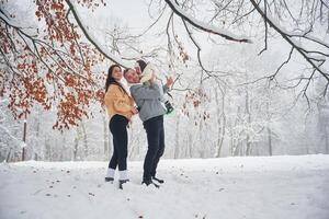 Happy, family of man, woman and little son is on the winter meadow and forest photo