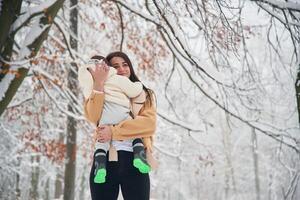 Woman, with, her little boy is in the winter forest on the meadow photo