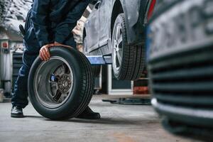 Close, up ,view of man that is moving tire of the car photo