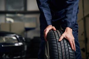 Close up, view of man that is moving tire of the car photo