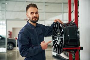Disk ,of the wheel. Car repairman is in the garage with automobile photo