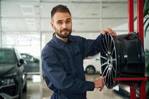 Disk, of the wheel. Car repairman is in the garage with automobile photo