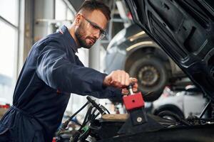 Car, repairman is in the garage with automobile photo