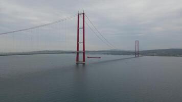 Aerial view of cargo ship turning near Turkish suspension bridge video