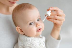 Baby receiving medication from a dropper held by a caring parent in a soft, nurturing environment, emphasizing health and wellness for infants, medication dropper concept photo