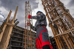 Construction Worker Assembling Rebar Framework at a Building Site photo