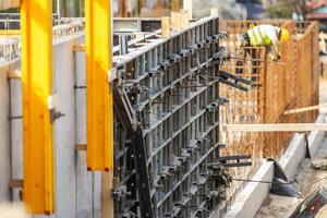 Construction Worker Assembling Concrete Forms on a Building Site photo