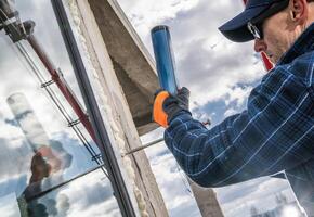 Worker Installing Glass in a Construction Project Under Cloudy Sky photo